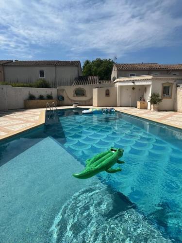 a swimming pool with a toy turtle in the water at Villa Victoire au coeur de la Provence in Venelles