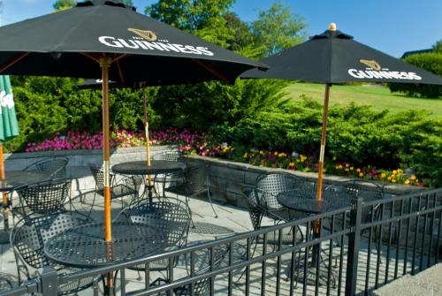 two tables and chairs with umbrellas on a patio at Union Bluff Hotel & Meeting House in York Beach