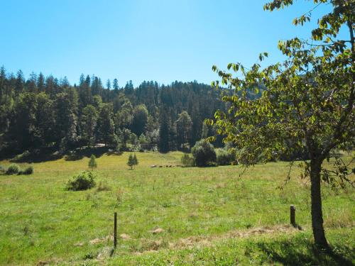 a field with a tree and some animals in a field at Holiday Home Bistenhof by Interhome in Hinterzarten