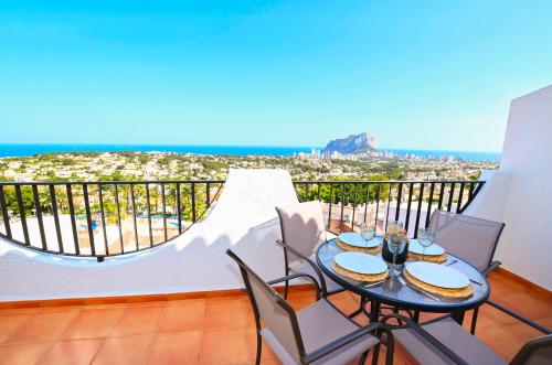a balcony with a table and chairs and the ocean at Beautiful cozy bungalow in calpe pool paradise! 08 in Calpe