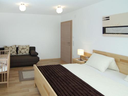 a bedroom with a bed and a couch at Holiday Home Schiestl by Interhome in Ramsau