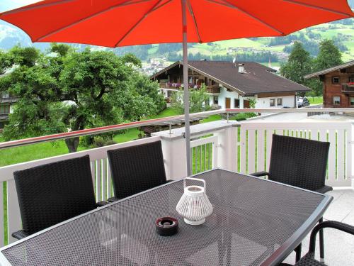 a black table with a red umbrella on a balcony at Holiday Home Schiestl by Interhome in Ramsau