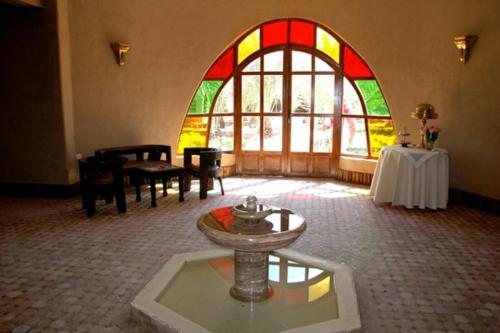 a room with a large stained glass window and a table at La Rose Du Desert in Erfoud