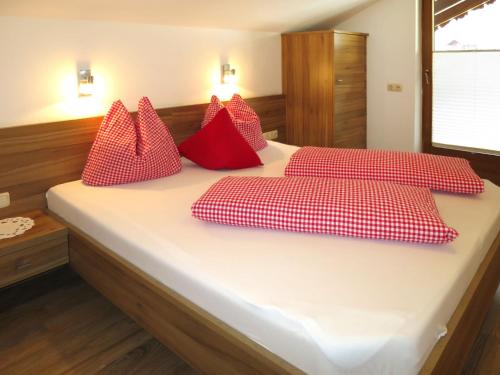 Un dormitorio con dos camas con almohadas rojas sobre ellas. en Apartment Neuner-2 by Interhome, en Hippach