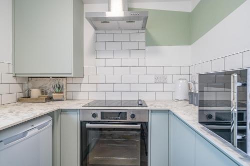 a kitchen with white cabinets and an oven at Gorgeous New 1 Bedroom Penthouse Flat in Morecambe