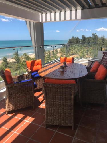 a patio with a table and chairs and the ocean at Luxury Penthouse, Nilaveli in Trincomalee