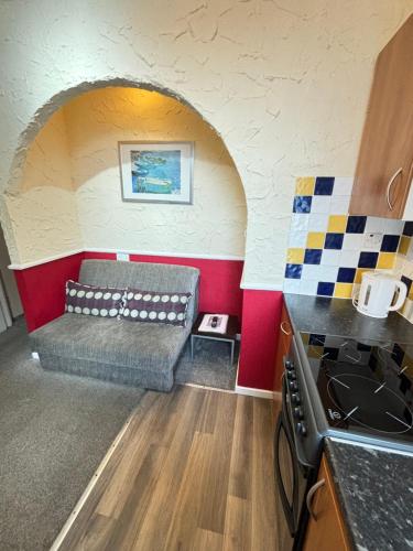 a living room with a couch in a kitchen at Lindisfarne Holiday Apartments - Families & Couples Only in Blackpool