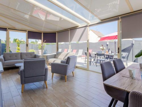 un soggiorno con sedie, tavoli e finestre di Holiday Home des Brigadies by Interhome a Créances