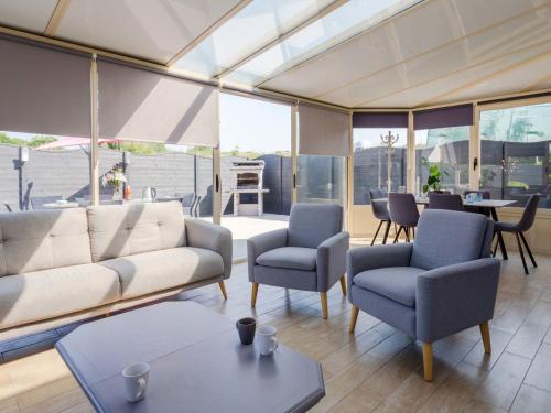 un soggiorno con un divano, sedie e un tavolo di Holiday Home des Brigadies by Interhome a Créances