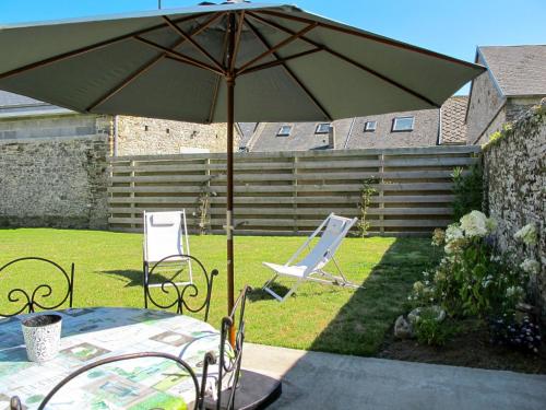 a table and chairs with an umbrella in a yard at Holiday Home La Lucerie by Interhome in Bretteville-sur-Ay