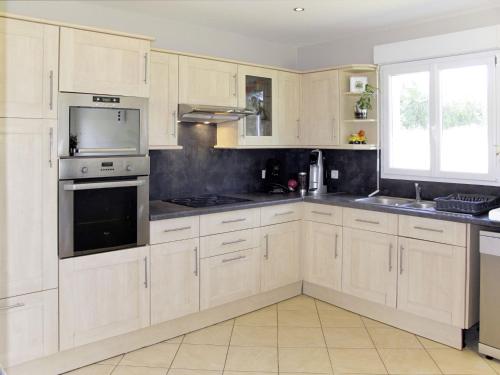 une cuisine avec des armoires blanches et des appareils en acier inoxydable dans l'établissement Holiday Home les Dunes du Havre by Interhome, à Glatigny