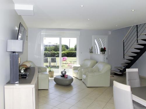 un soggiorno con mobili bianchi e una scala di Holiday Home les Dunes du Havre by Interhome a Glatigny