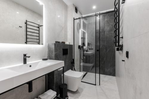 a bathroom with a toilet and a sink and a shower at Glacier Premium Apartments in Bukovel