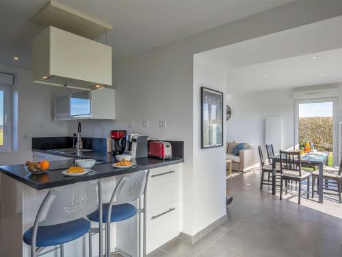 une cuisine et un salon avec un comptoir et des chaises dans l'établissement Holiday Home Ty Mamm by Interhome, à Kerlouan