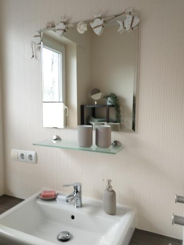 a bathroom with a sink and a mirror at Ferienwohnung Marita in Rietberg