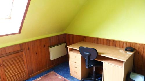 Cette chambre verte comprend un bureau et une chaise. dans l'établissement Peace Room, à Veigné