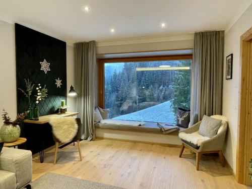 a living room with a large window and a couch at Apartment Panorama Chalet Tirol by Interhome in Auffach