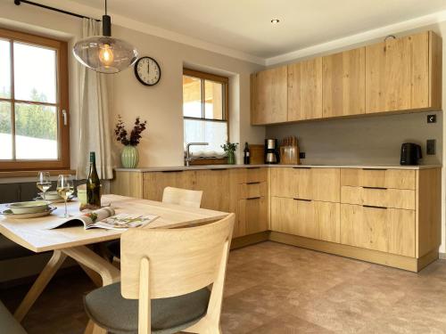 a kitchen with a table and a clock on the wall at Apartment Panorama Chalet Tirol by Interhome in Auffach