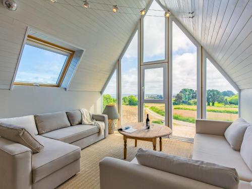 a living room with white furniture and large windows at Holiday Home La Belle Vue by Interhome in Locquirec