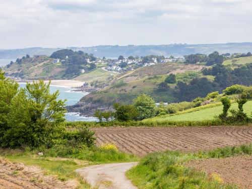a dirt road leading down a hill next to a beach at Holiday Home La Belle Vue by Interhome in Locquirec