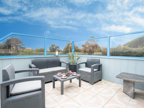 d'une terrasse avec des chaises et des tables sur un balcon. dans l'établissement Holiday Home des Aulnes by Interhome, à Cléder