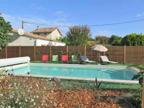 una piscina con sillas y una valla en Holiday Home Mon Poussin by Interhome, en Saint-Vivien-de-Médoc