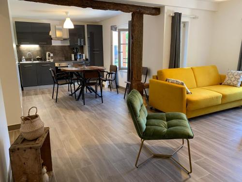 un salon avec un canapé jaune et une table dans l'établissement Appartement Les Vendanges Parking privé Gites1596, à Beblenheim