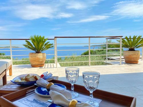 a table with wine glasses on top of a balcony at Villa Tempera in Vis