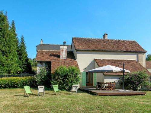 une maison avec des chaises, une table et un parasol dans l'établissement Holiday Home Le Moulin Lecomte by Interhome, à Saint-Romain-sur-Cher