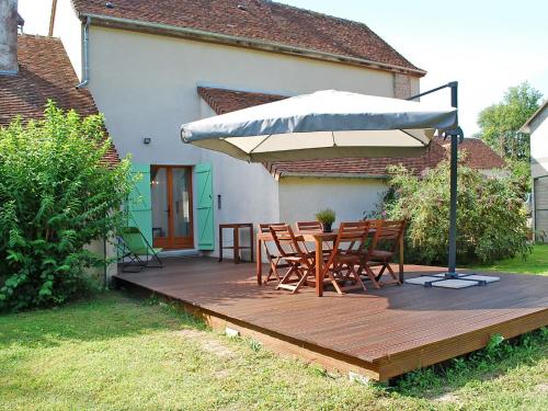 une terrasse en bois avec des chaises et un parasol dans l'établissement Holiday Home Le Moulin Lecomte by Interhome, à Saint-Romain-sur-Cher