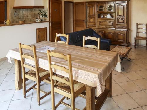 a dining room table with chairs and a couch at Holiday Home Le Mas by Interhome in Grillon