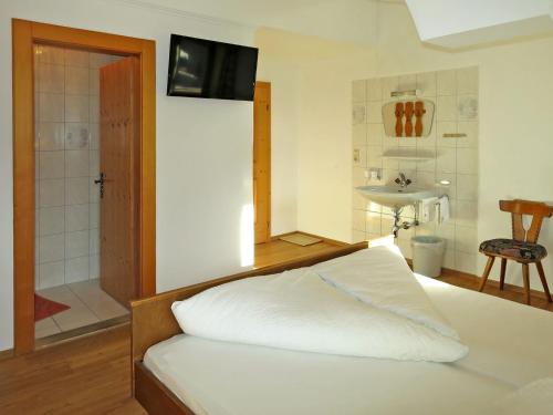 a bedroom with a bed and a bathroom with a sink at Apartment Heisenhaus-3 by Interhome in Ramsau im Zillertal