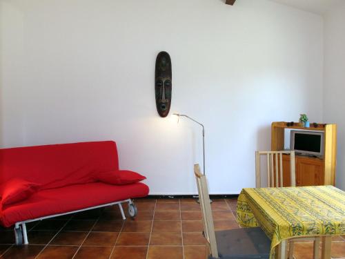 un salon avec un canapé rouge et une table dans l'établissement Apartment Le Colibri by Interhome, à Six-Fours-les-Plages