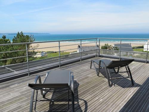 - deux tables et des chaises sur un balcon avec vue sur la plage dans l'établissement Holiday Home Gwel Ar Mor by Interhome, à Plonevez-Porzay