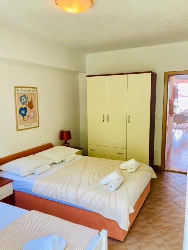 a bedroom with two beds and a cabinet at Apartments Juraković in Živogošće