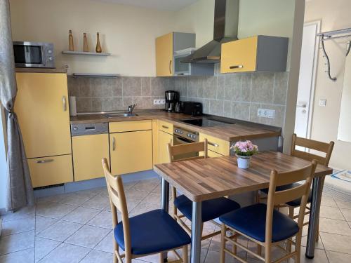 a kitchen with a wooden table and chairs at Apartment Müritz Ferienpark Röbel-15 by Interhome in Röbel