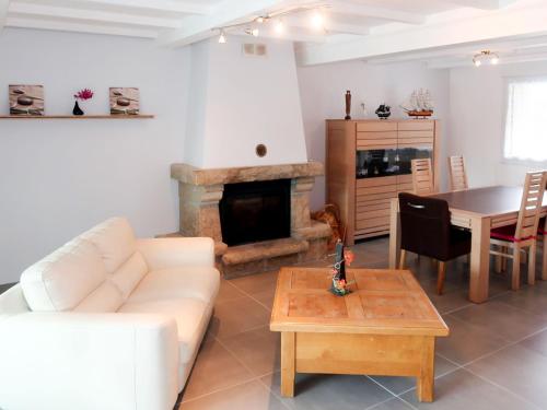 un salon avec un canapé blanc et une cheminée dans l'établissement Holiday Home La hutte de Panoramix by Interhome, à Cast