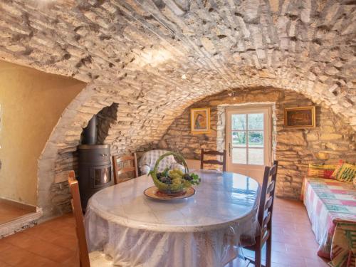 une salle à manger avec une table et un mur en pierre dans l'établissement Holiday Home Mas Magot by Interhome, à Mons