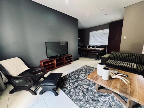 a living room with a couch and a television at Tredenham Boutique Hotel in Bloemfontein