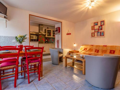 une salle à manger avec une table et des chaises rouges dans l'établissement Holiday Home Les Lutins by Interhome, à Commes