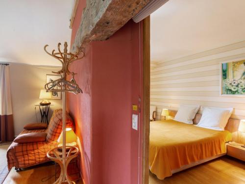 a bedroom with a bed and a chair at Holiday Home La Haute Gilberdière-2 by Interhome in Sartilly