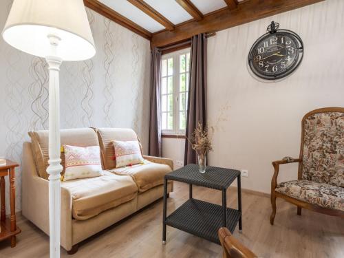 un salon avec un canapé et une horloge au mur dans l'établissement Holiday Home Tytisa N-1 by Interhome, à Barneville-Carteret