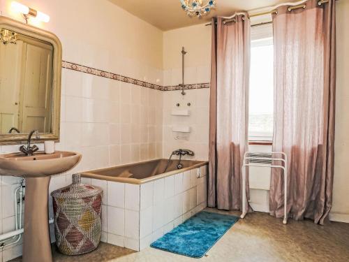 a bathroom with a tub and a sink at Holiday Home La douce Trégoroise by Interhome in Tréguier