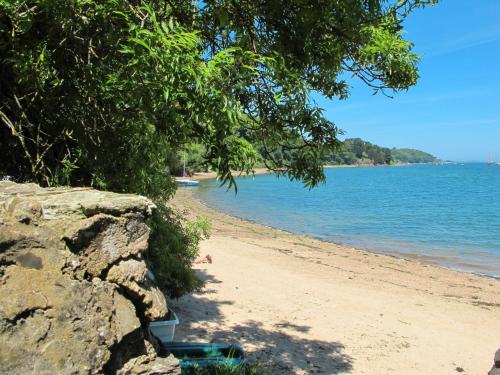 a sandy beach with trees and the water at Holiday Home La douce Trégoroise by Interhome in Tréguier
