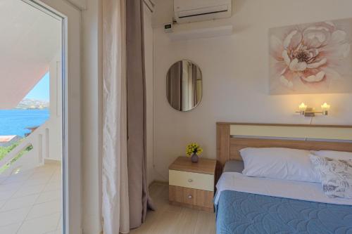 a bedroom with a bed and a view of the ocean at Magdalena with mountain and seaview in Metajna