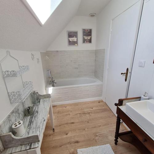 une salle de bain avec une baignoire et un lavabo dans l'établissement Appartement Le Lioran By Les Monts du Cantal, à Murat
