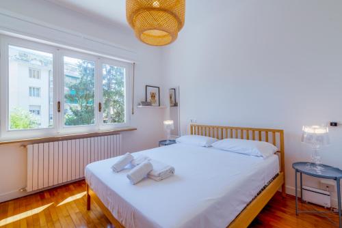 サンレモにあるVilla Center Sanremoのタオルが敷かれた大きな白いベッドのある寝室