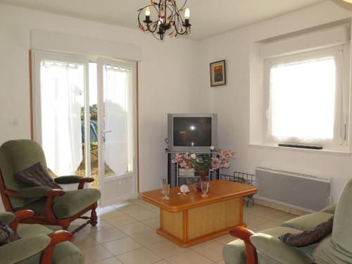 un salon avec une télévision et une table dans l'établissement Holiday Home Chez Yvonne by Interhome, à Pleubian