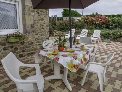 un tavolo con sedie e un ombrellone in un patio di Holiday Home Chez Yvonne by Interhome a Pleubian