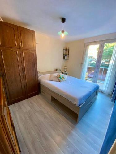 une chambre avec un lit et une grande fenêtre dans l'établissement Le central, avec terrasse et parking saint raphael, à Saint-Raphaël